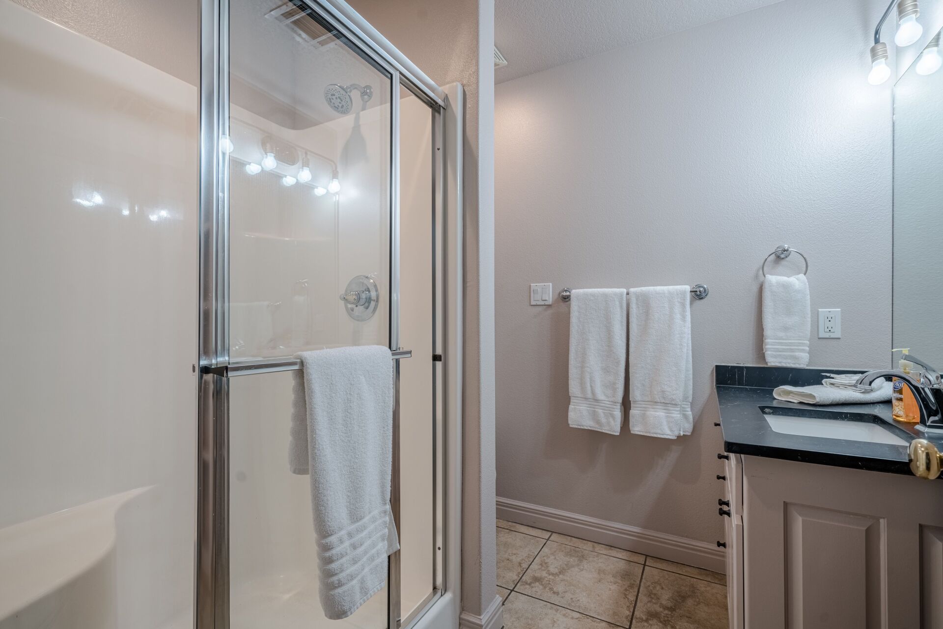 A bathroom with a walk in shower , sink , and mirror.
