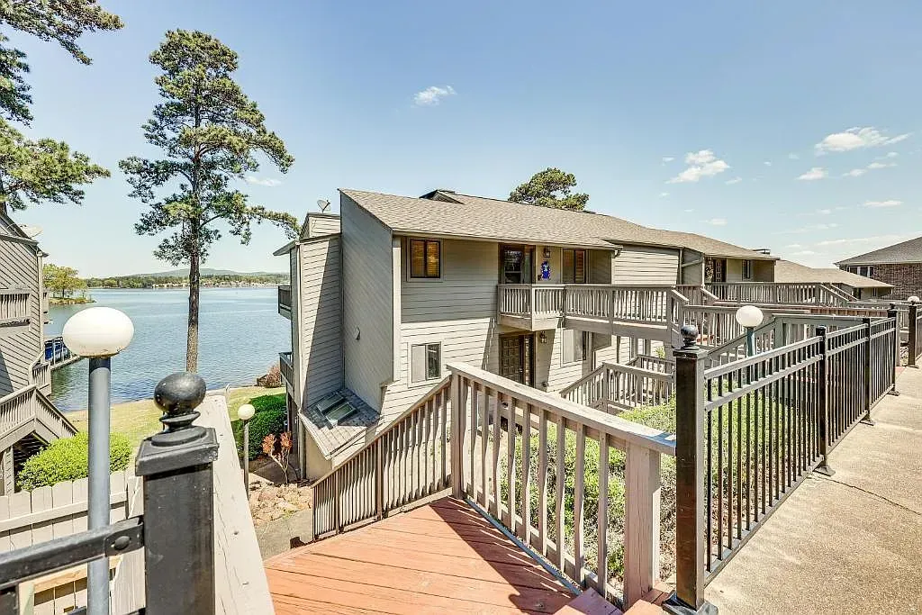 A balcony with a view of a lake and a building in the background.