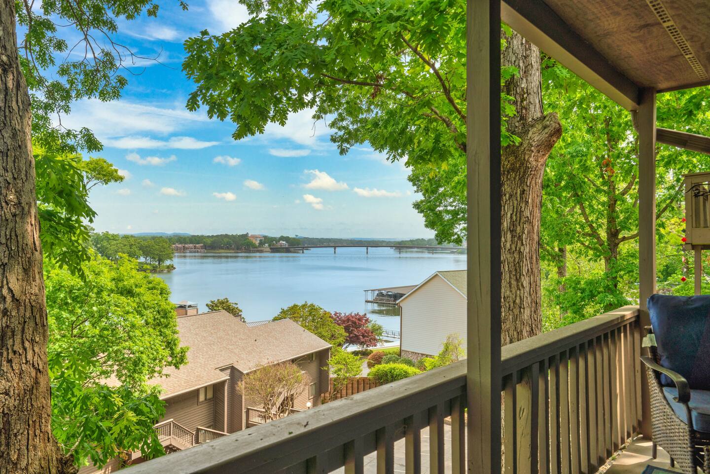 A balcony with a view of a lake surrounded by trees