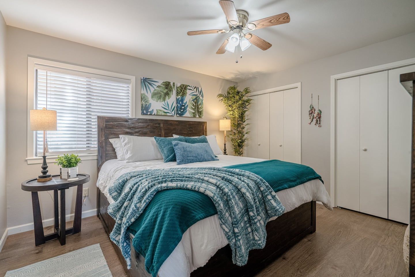 A bedroom with a king size bed , a ceiling fan and a window.