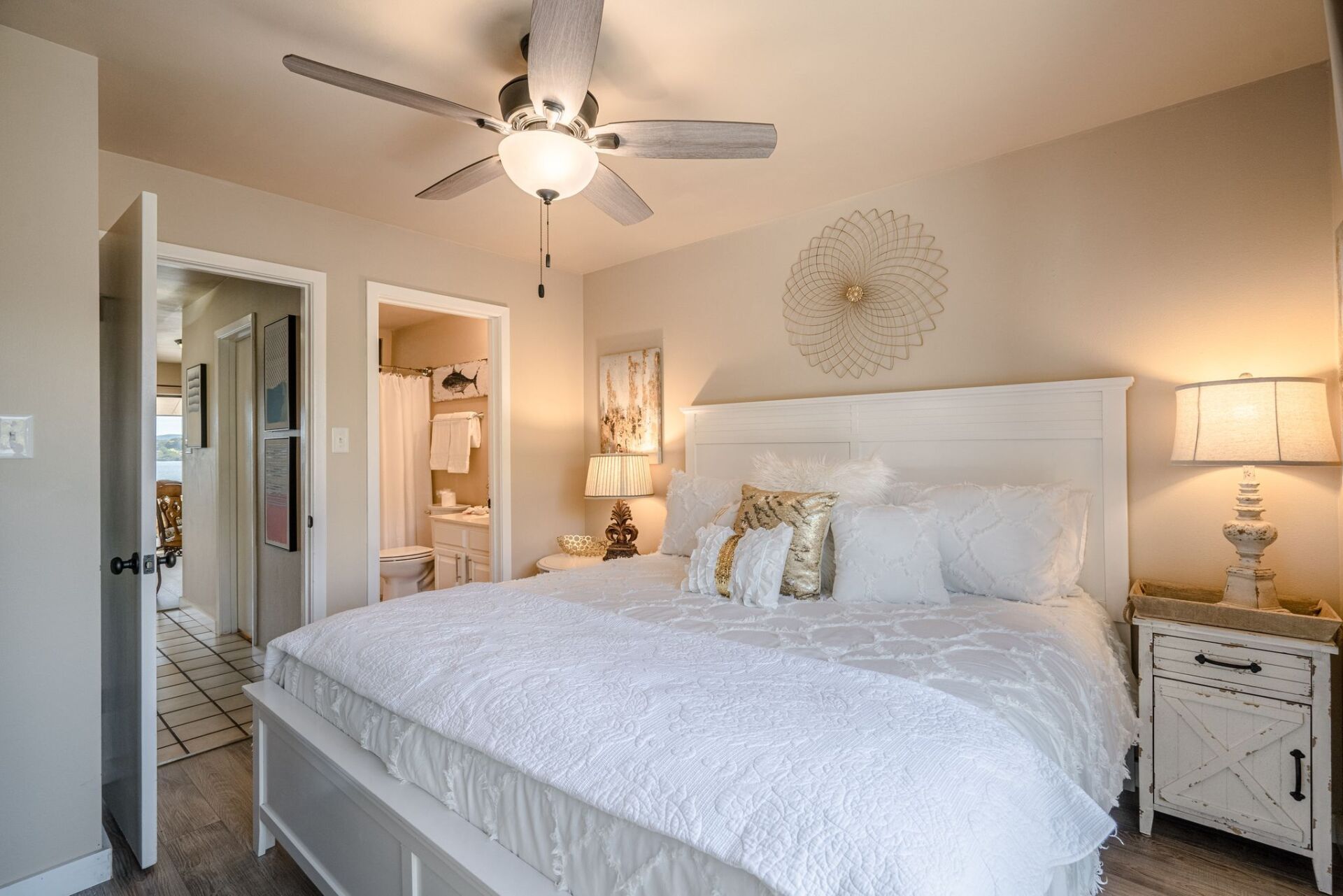 A bedroom with a king size bed and a ceiling fan.