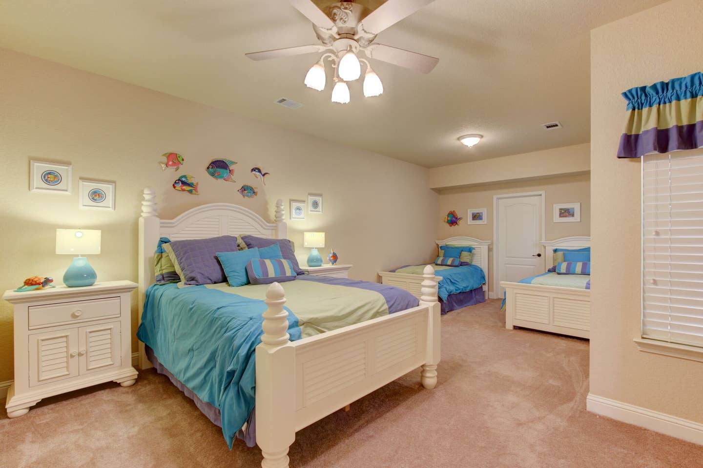 A bedroom with two beds and a ceiling fan.