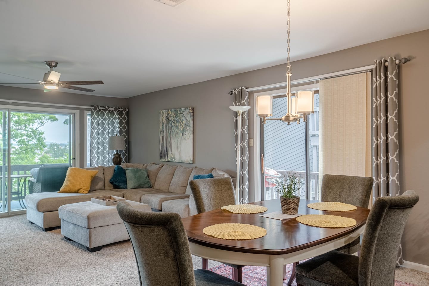 A living room with a dining table and chairs and a sliding glass door.