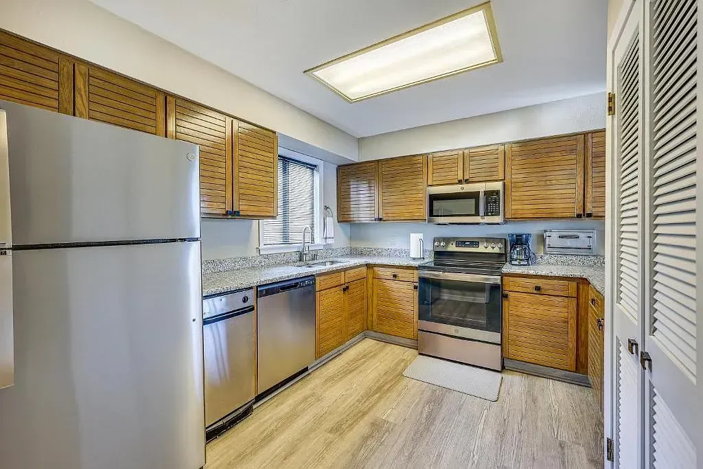 A kitchen with stainless steel appliances and wooden cabinets