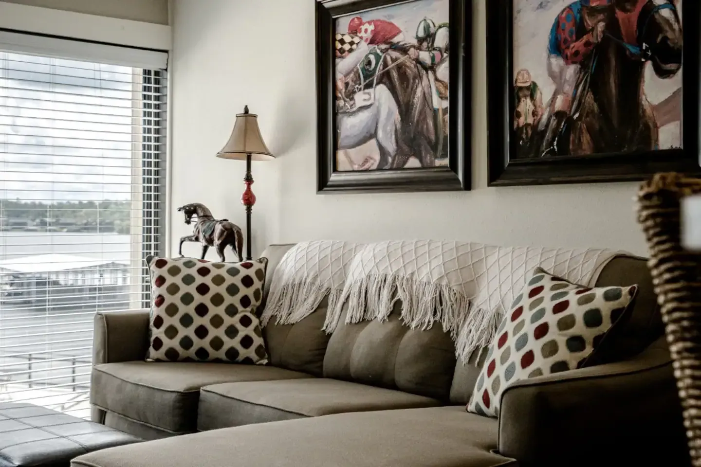 A living room with a couch and two pictures on the wall.