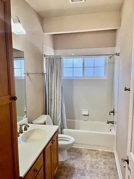 A bathroom with a toilet , sink , tub and shower.
