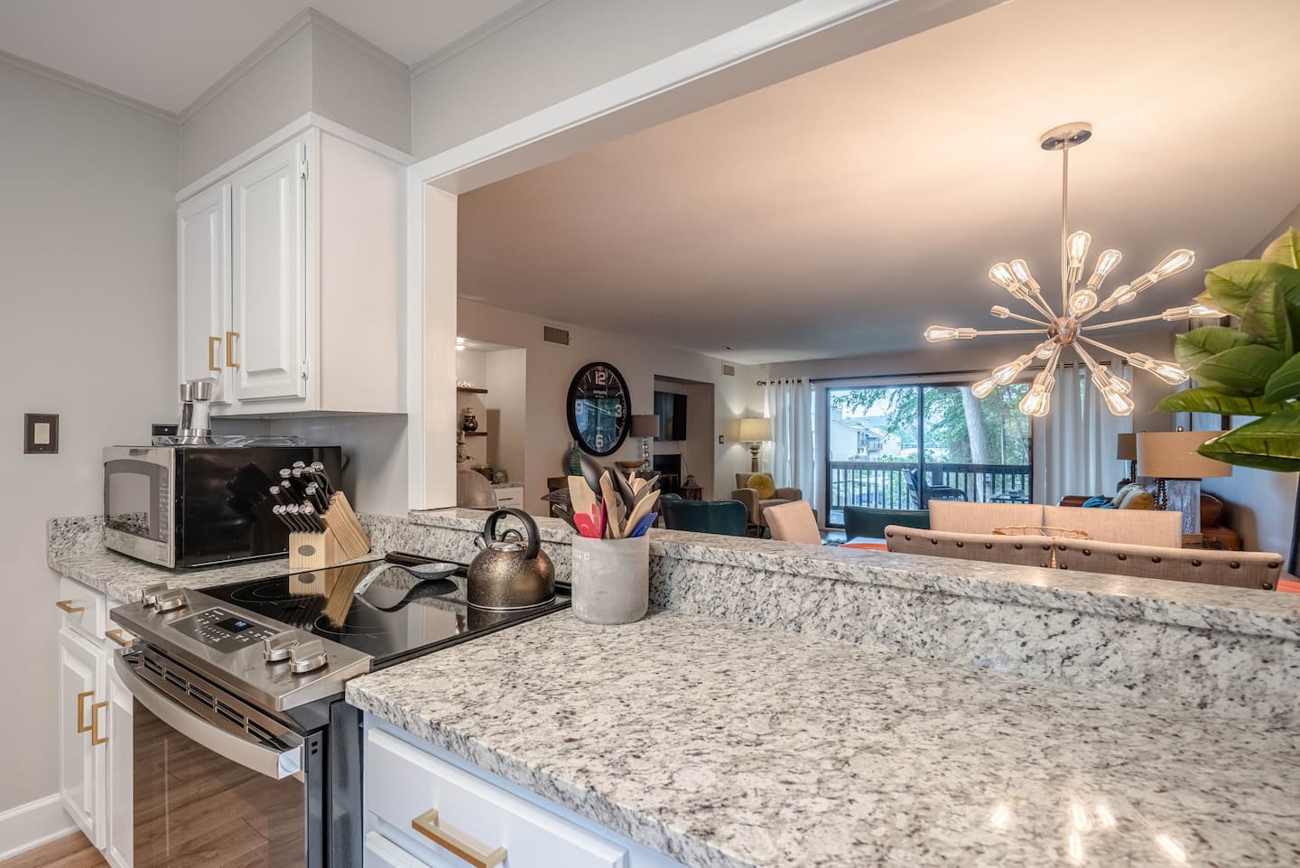 A kitchen with granite counter tops , a stove and a microwave.