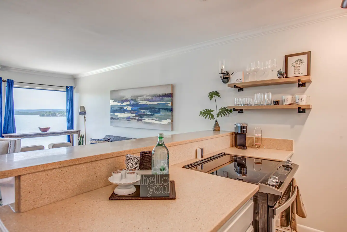 A kitchen with a stove , sink , and shelves.
