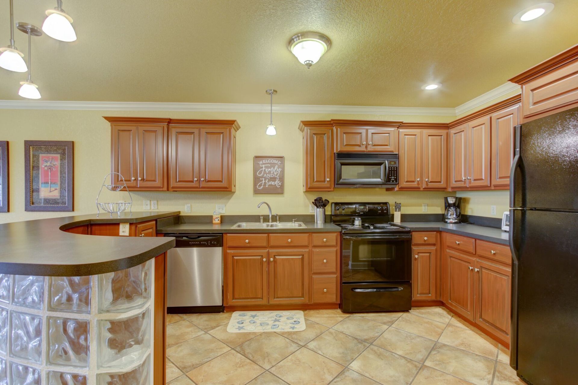 A kitchen with wooden cabinets , stainless steel appliances , and a black refrigerator.