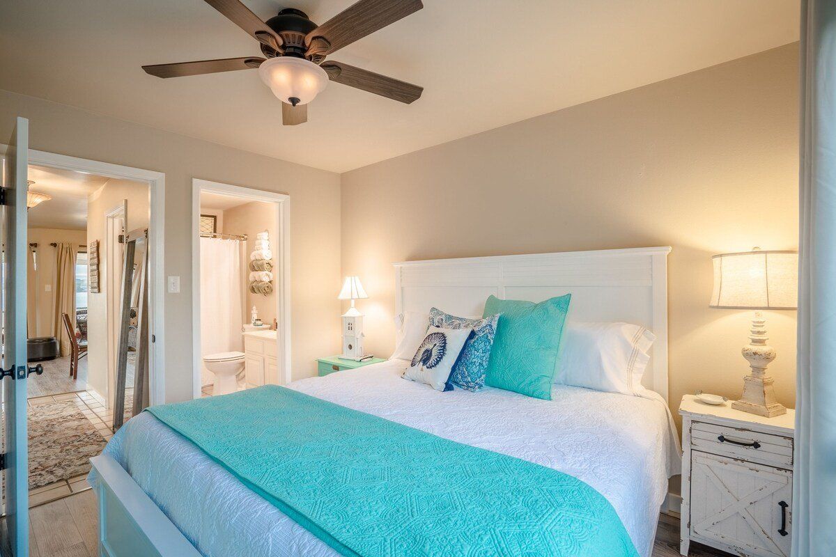 A bedroom with a king size bed and a ceiling fan.