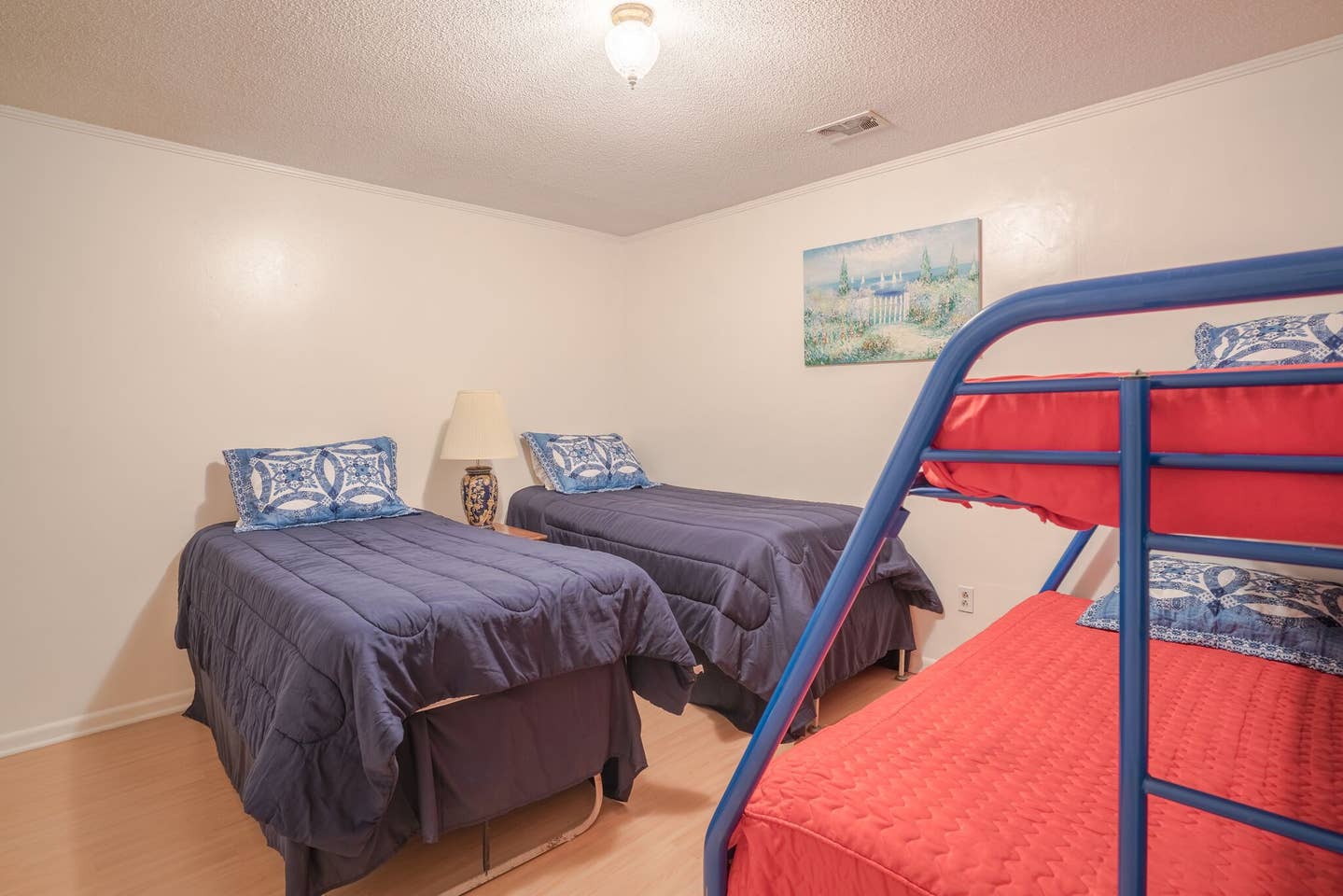 A bedroom with two beds and a bunk bed.