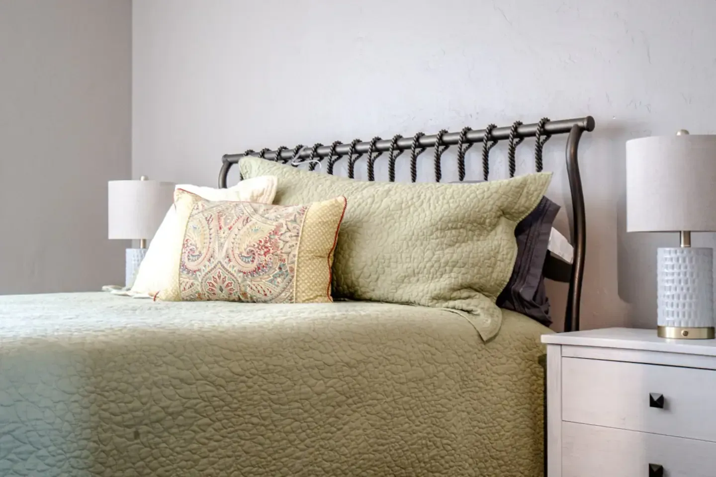 A bedroom with a bed , two lamps and a nightstand