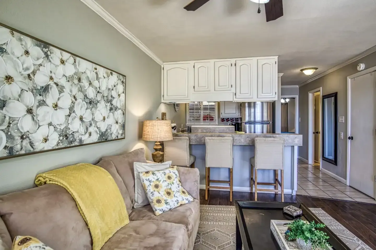 A living room with a couch , table , chairs and a ceiling fan.