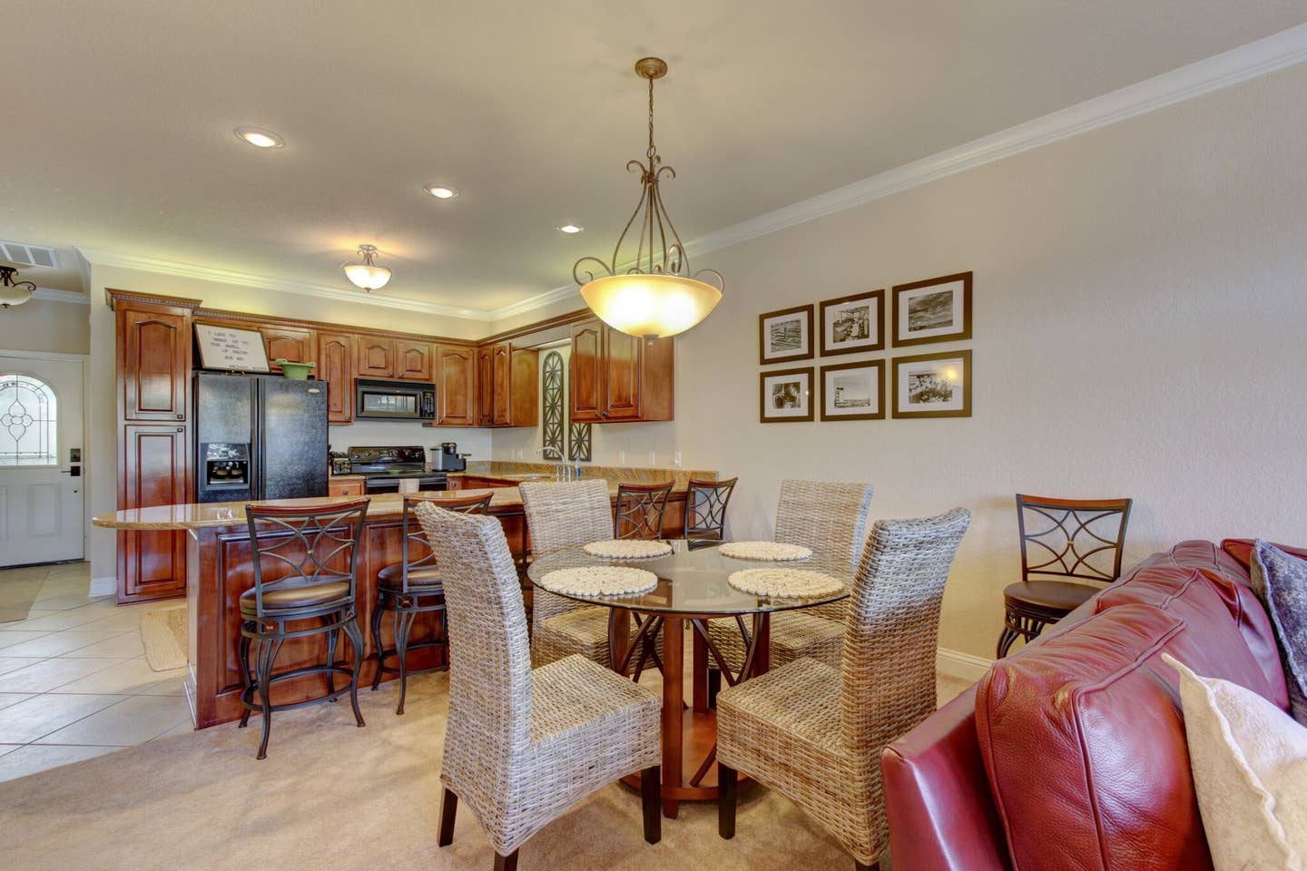 A living room with a dining table and chairs and a red couch.