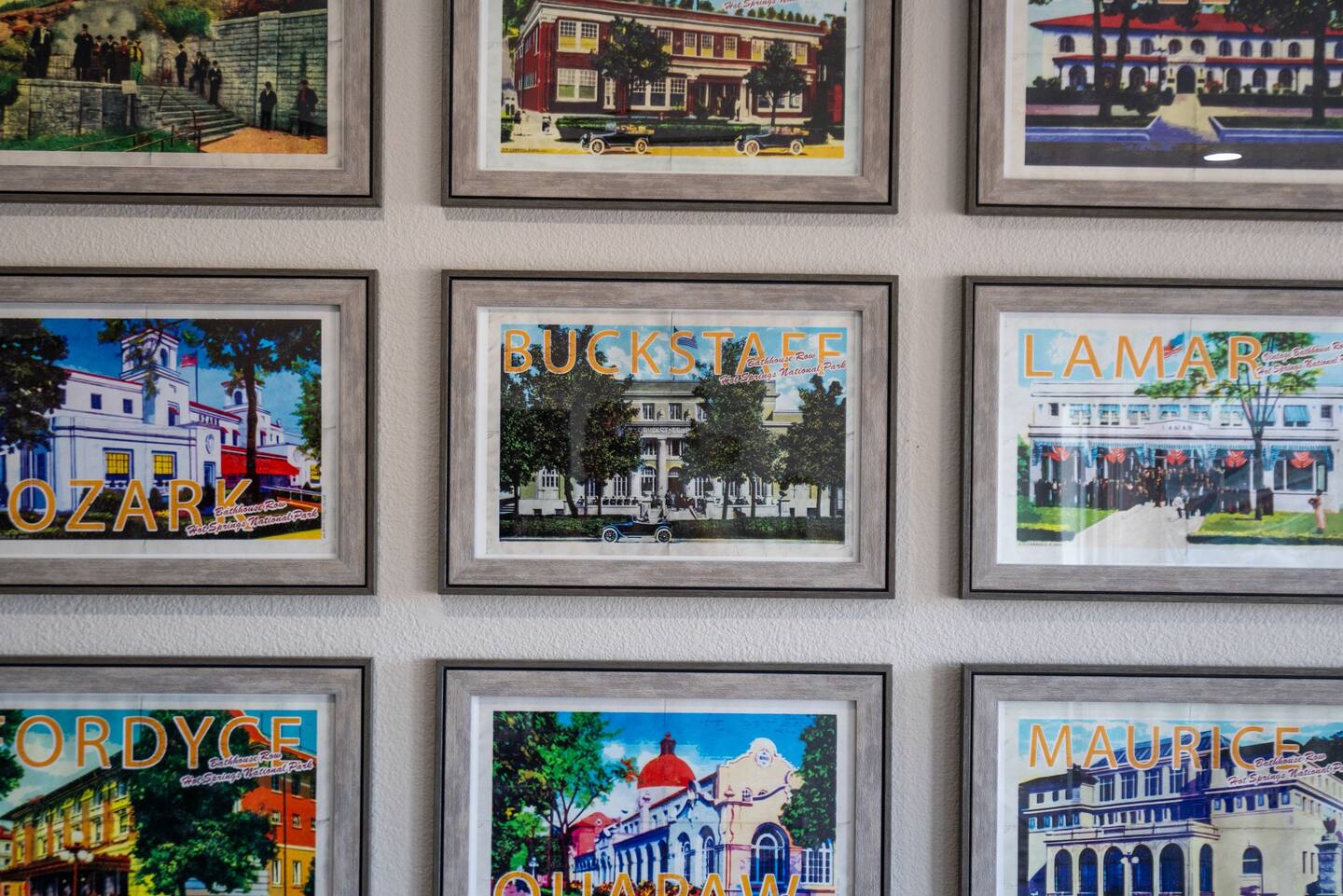 A wall with a bunch of framed pictures on it.