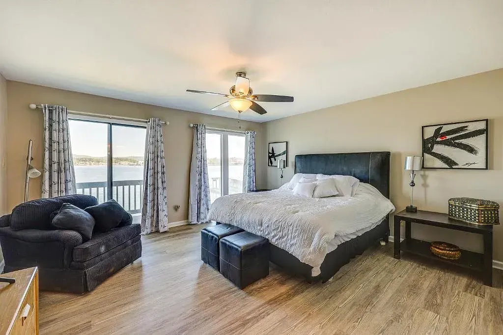 A large bedroom with a king size bed , a couch , and a ceiling fan.