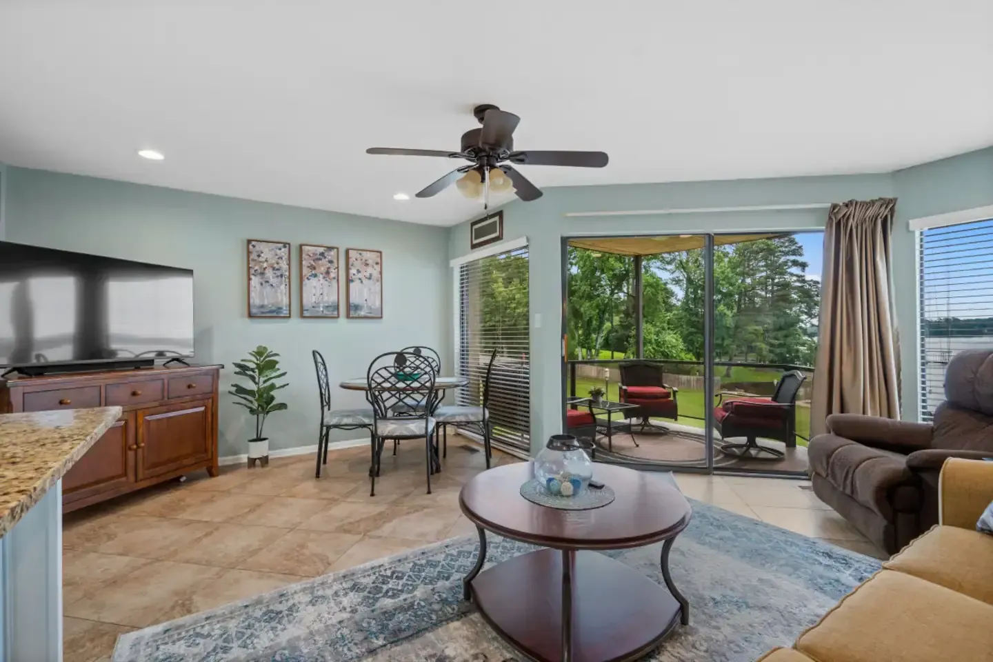 A living room with a ceiling fan , a couch , a table and chairs.