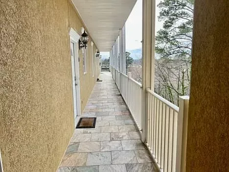 A long hallway between two buildings with a balcony.