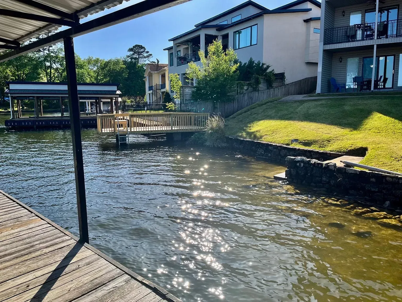 A large body of water with a dock and a house in the background