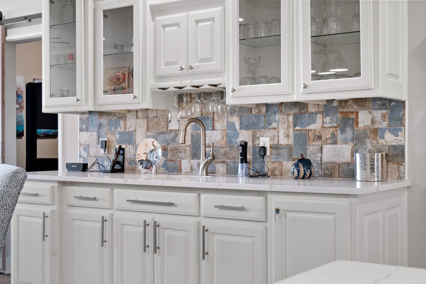 A kitchen with white cabinets , a sink , and a counter top.