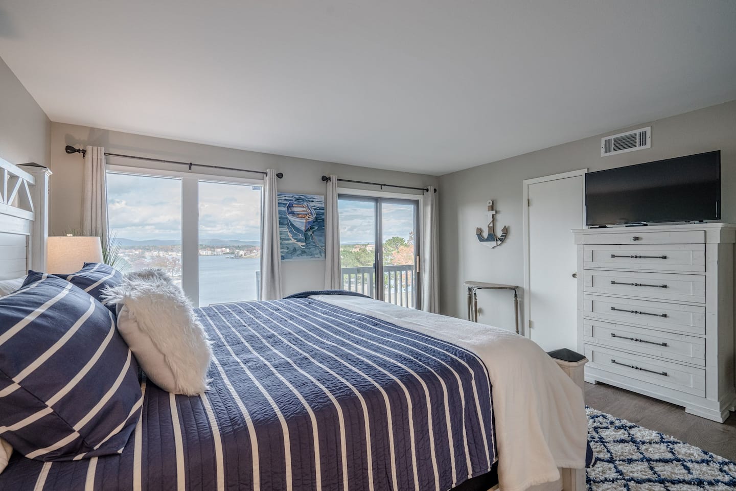 A bedroom with a king size bed and a flat screen tv.