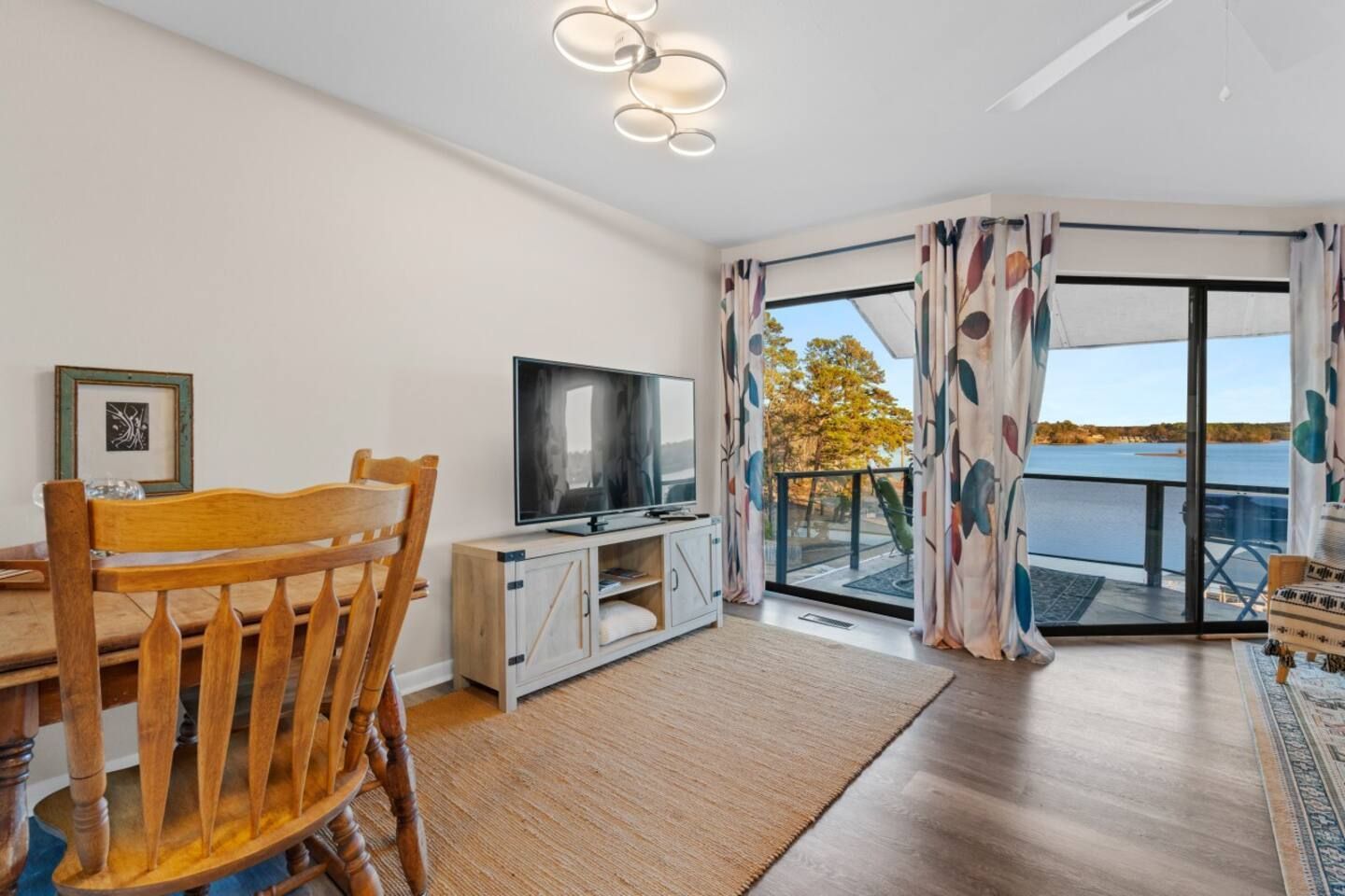 A living room with a dining table and chairs and a television.