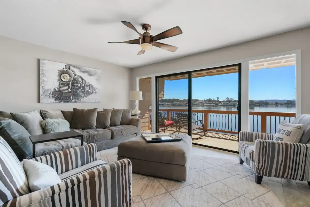 A living room with a couch , chairs , and a ceiling fan.