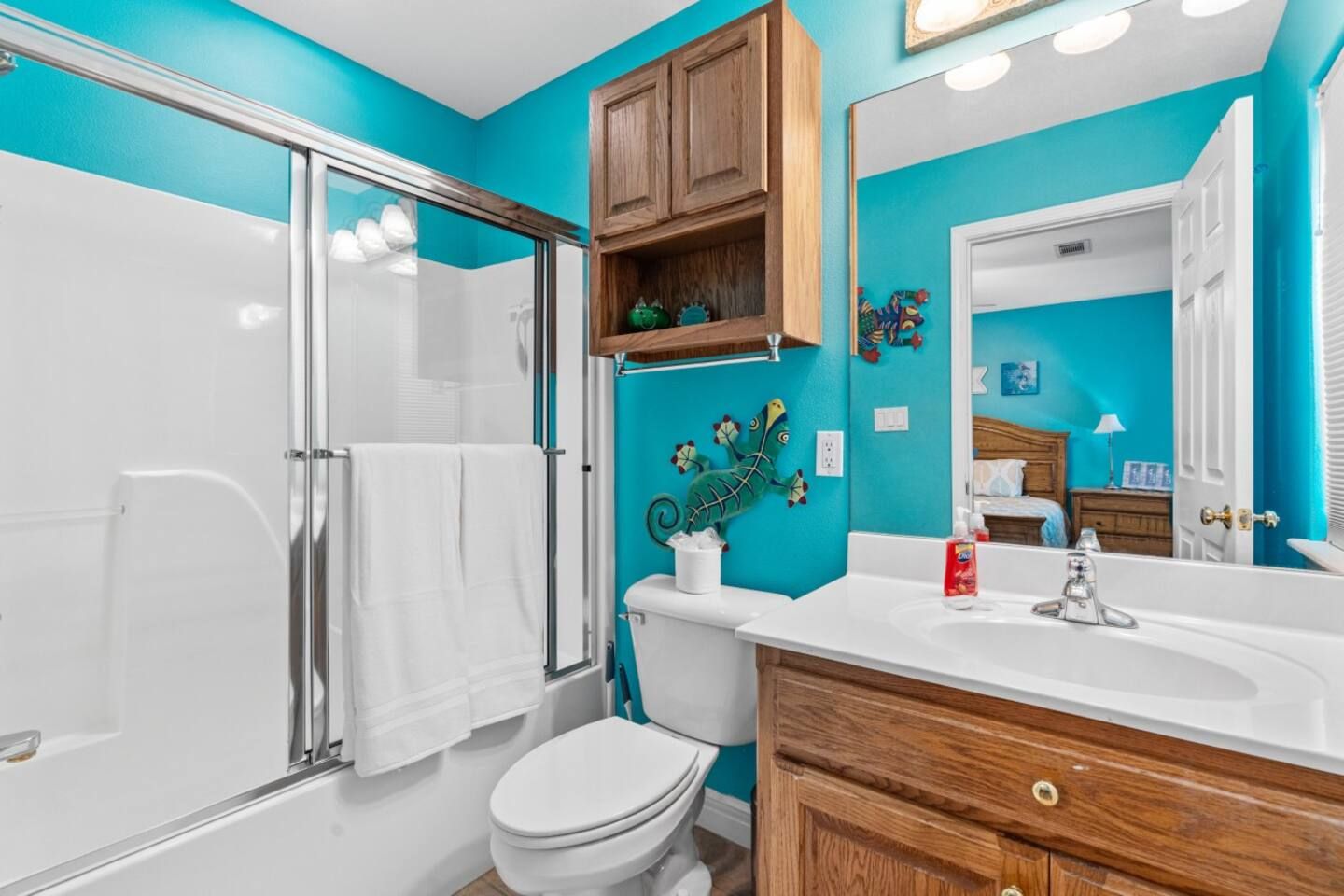 A bathroom with blue walls , a toilet , sink , and shower.