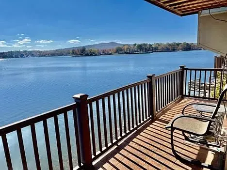 There is a deck with a view of a lake.