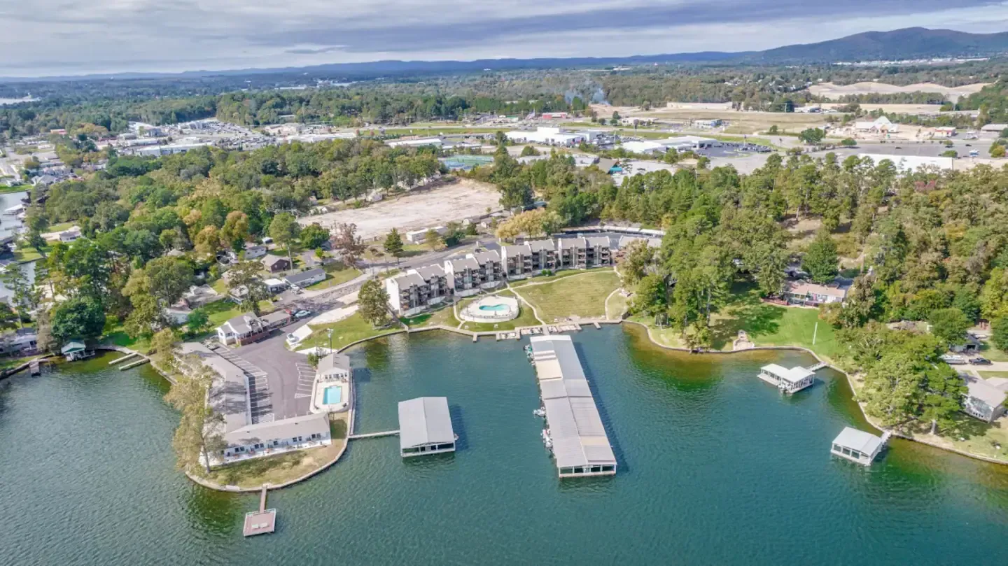 An aerial view of a lake surrounded by trees and buildings.