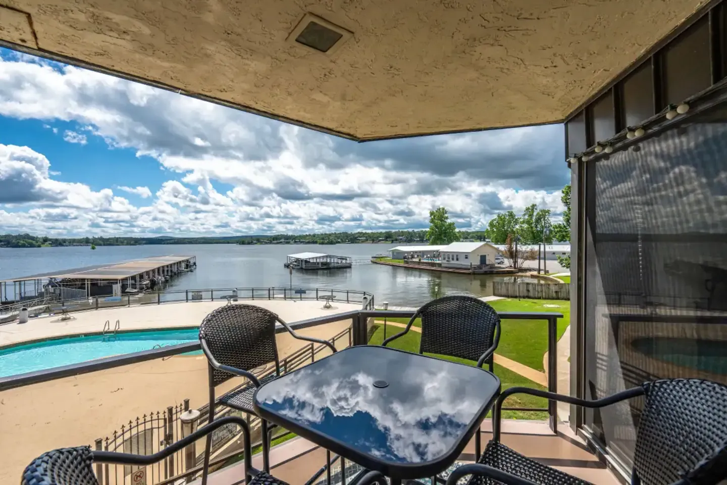 A balcony with a table and chairs overlooking a lake.