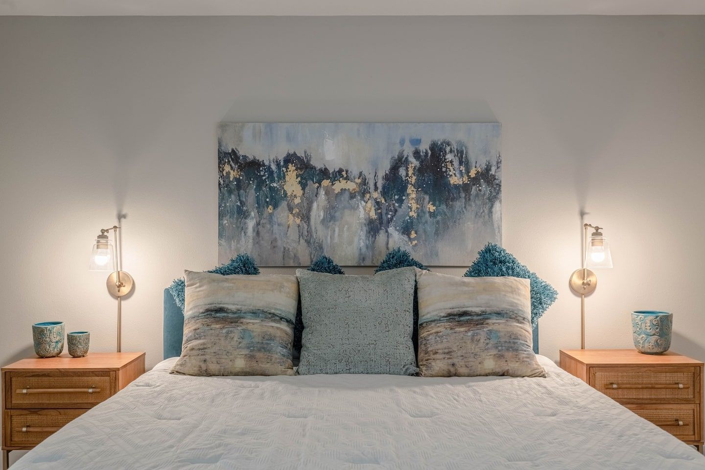 There is a painting on the wall above the bed.