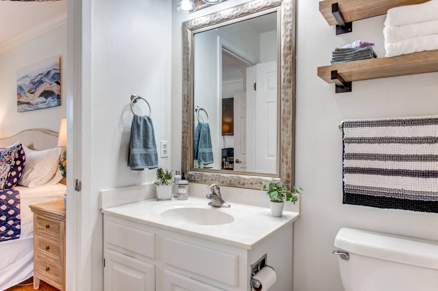 A bathroom with a sink , toilet and mirror.