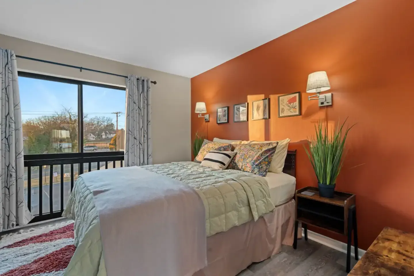 A bedroom with a bed , nightstand , and sliding glass door.