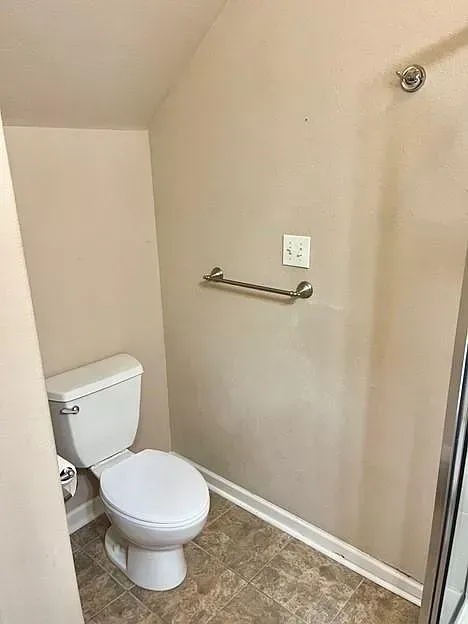 A bathroom with a toilet and a shower.