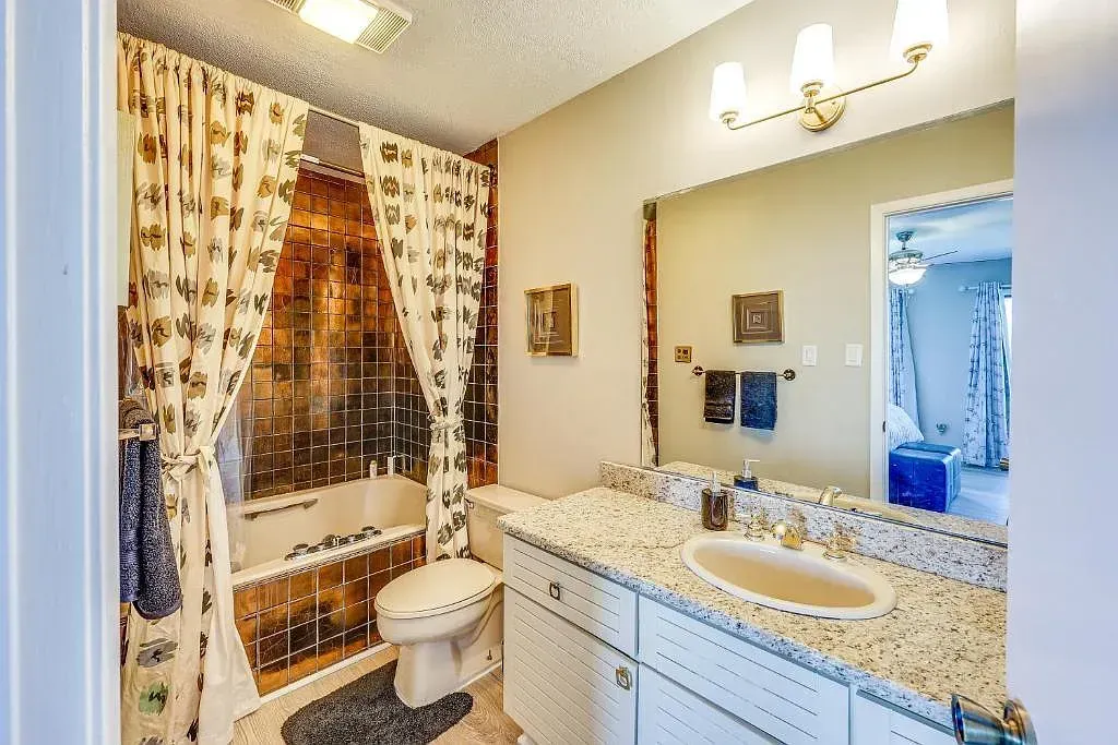 A bathroom with a sink , toilet , bathtub and mirror.
