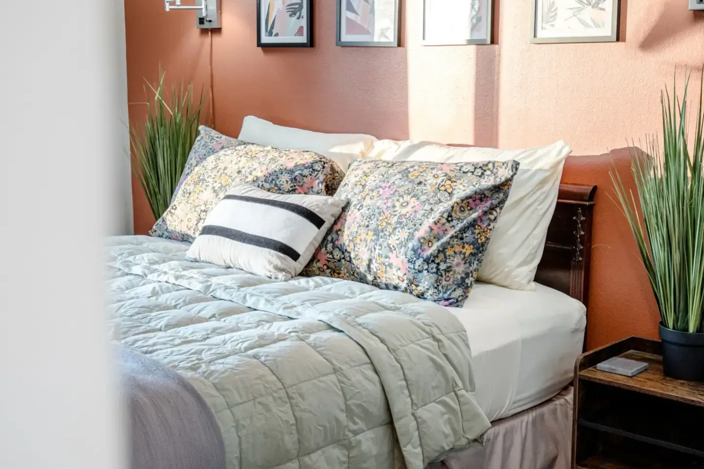 A bed with a quilt and pillows in a bedroom.