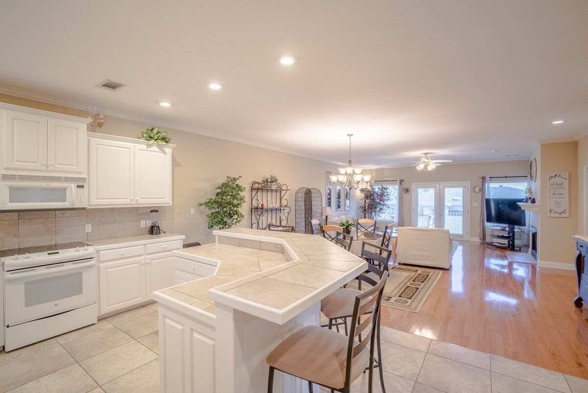 A kitchen with white cabinets and a large island in the middle of the room.