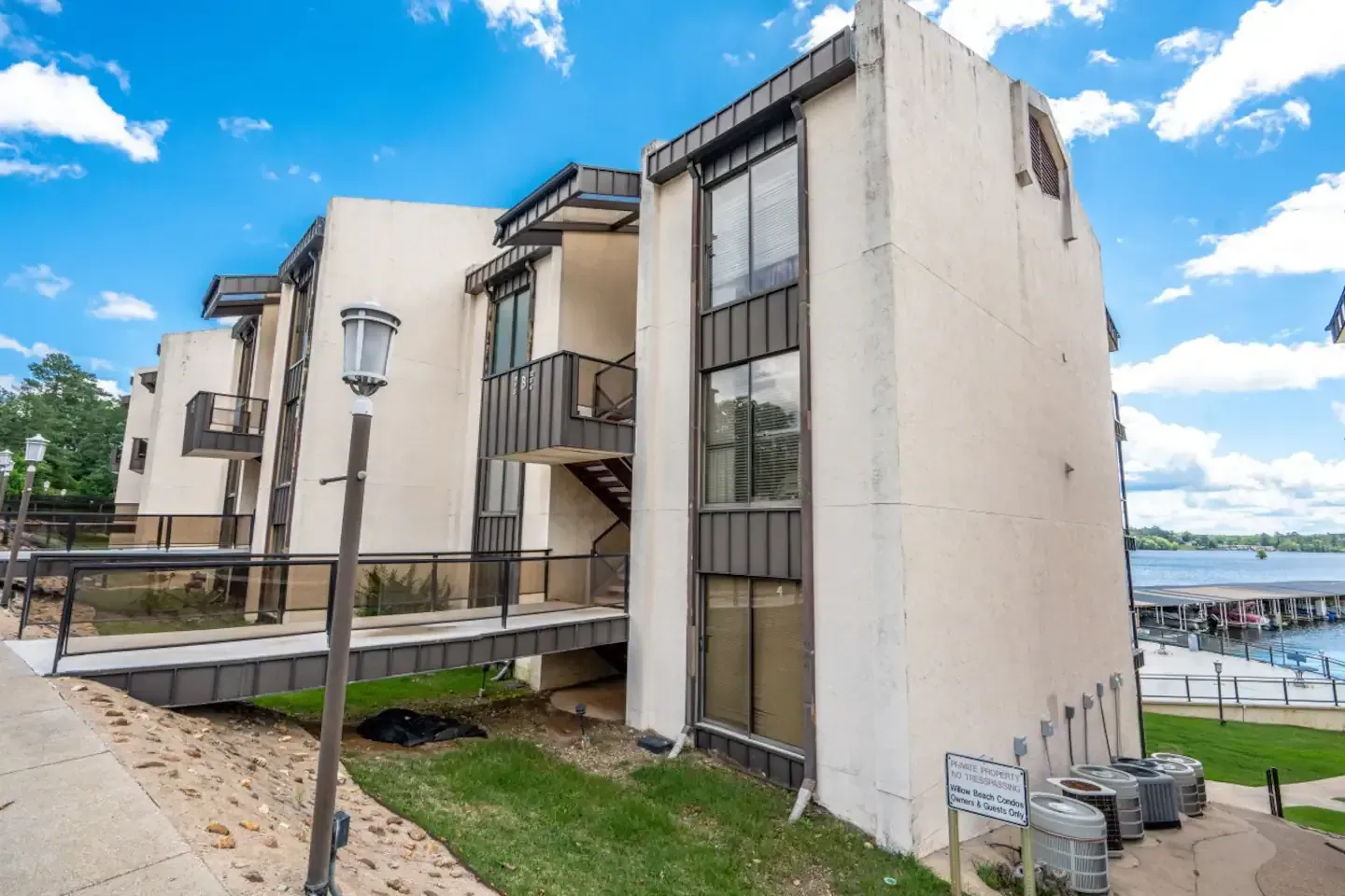 A large building with a lot of windows and stairs next to a body of water.