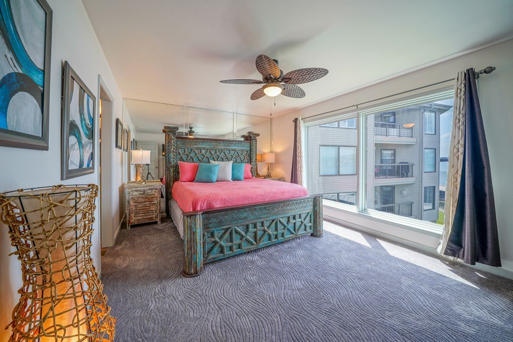 A large bedroom with a king size bed and a ceiling fan.