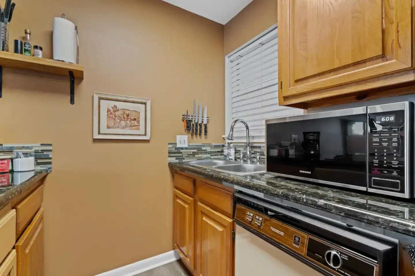 A kitchen with a sink , microwave , and dishwasher.
