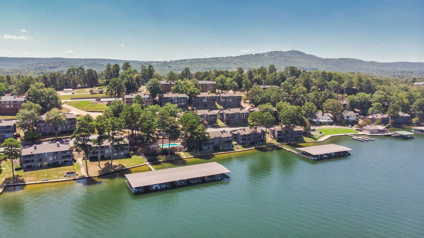 An aerial view of a lake surrounded by houses and trees.