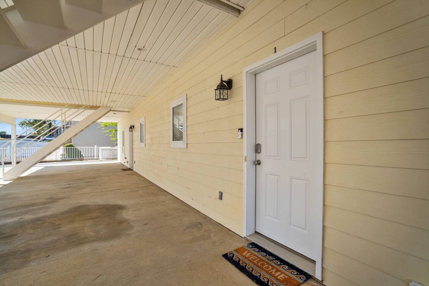 A white door is on the side of a building.