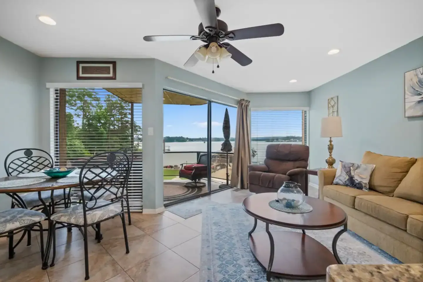 A living room with a couch , table , chairs and a ceiling fan