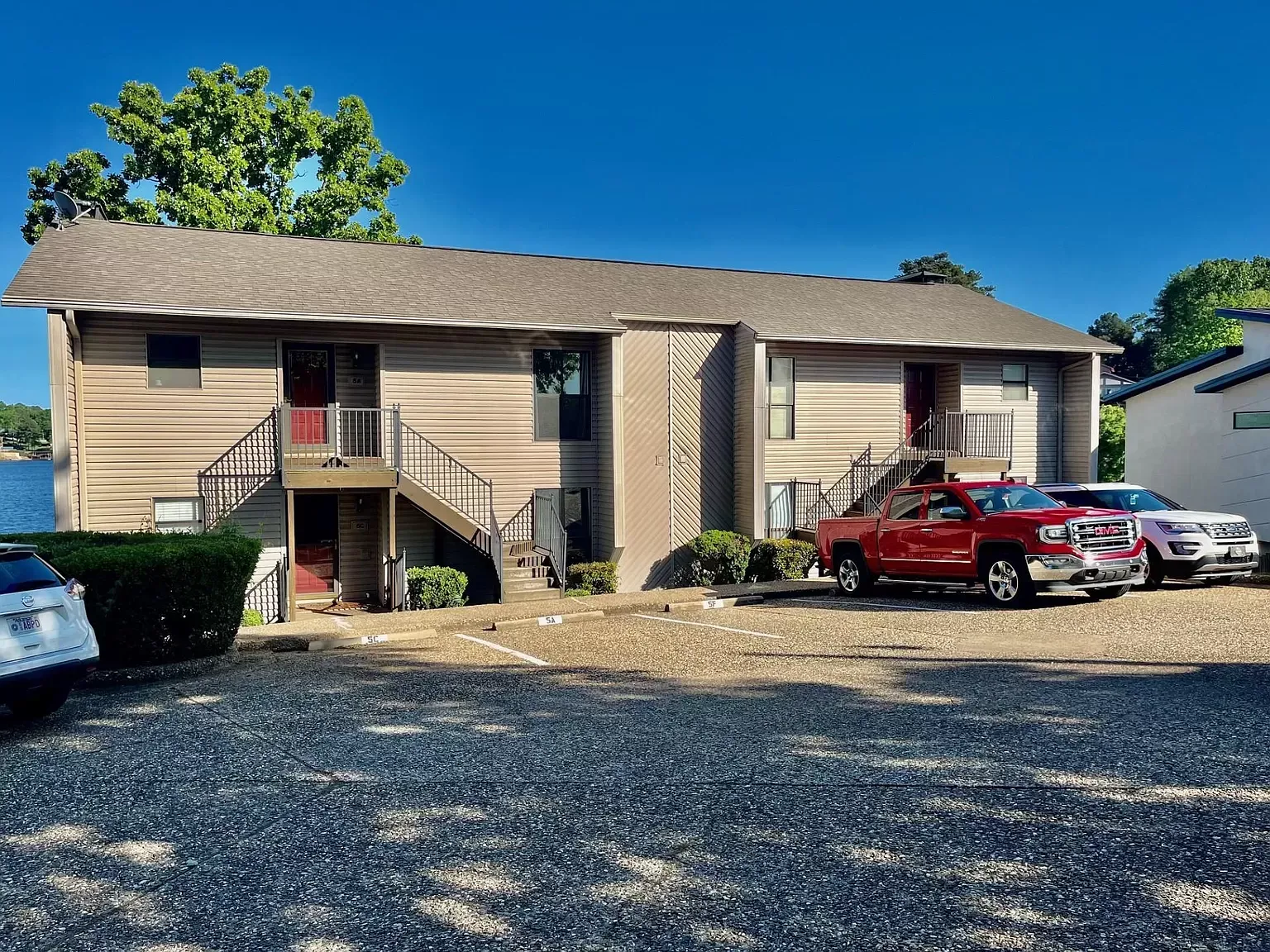 A house with a lot of cars parked in front of it.
