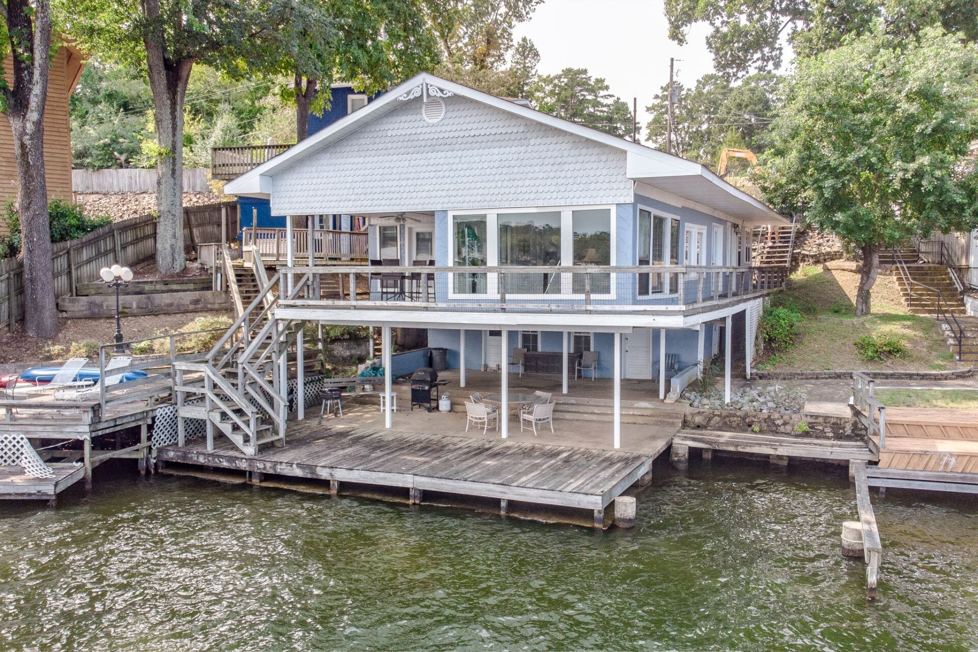 An aerial view of a house on stilts on a lake with a dock.