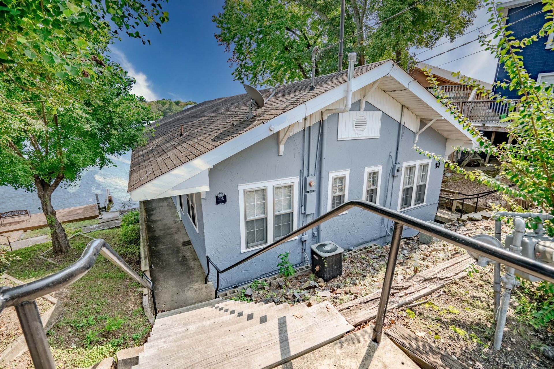 A small gray house with stairs leading up to it.