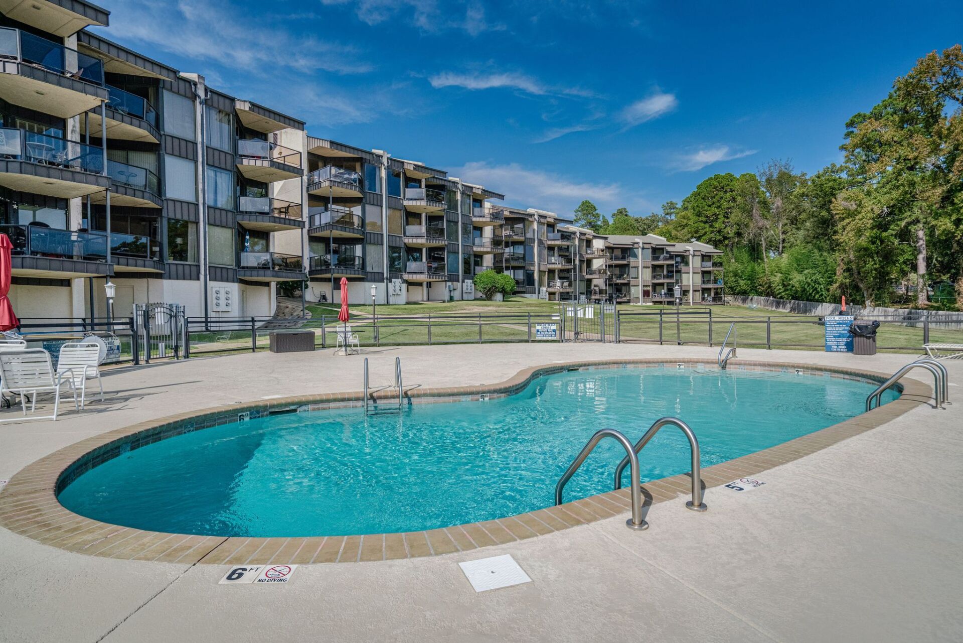 There is a large swimming pool in front of a building.