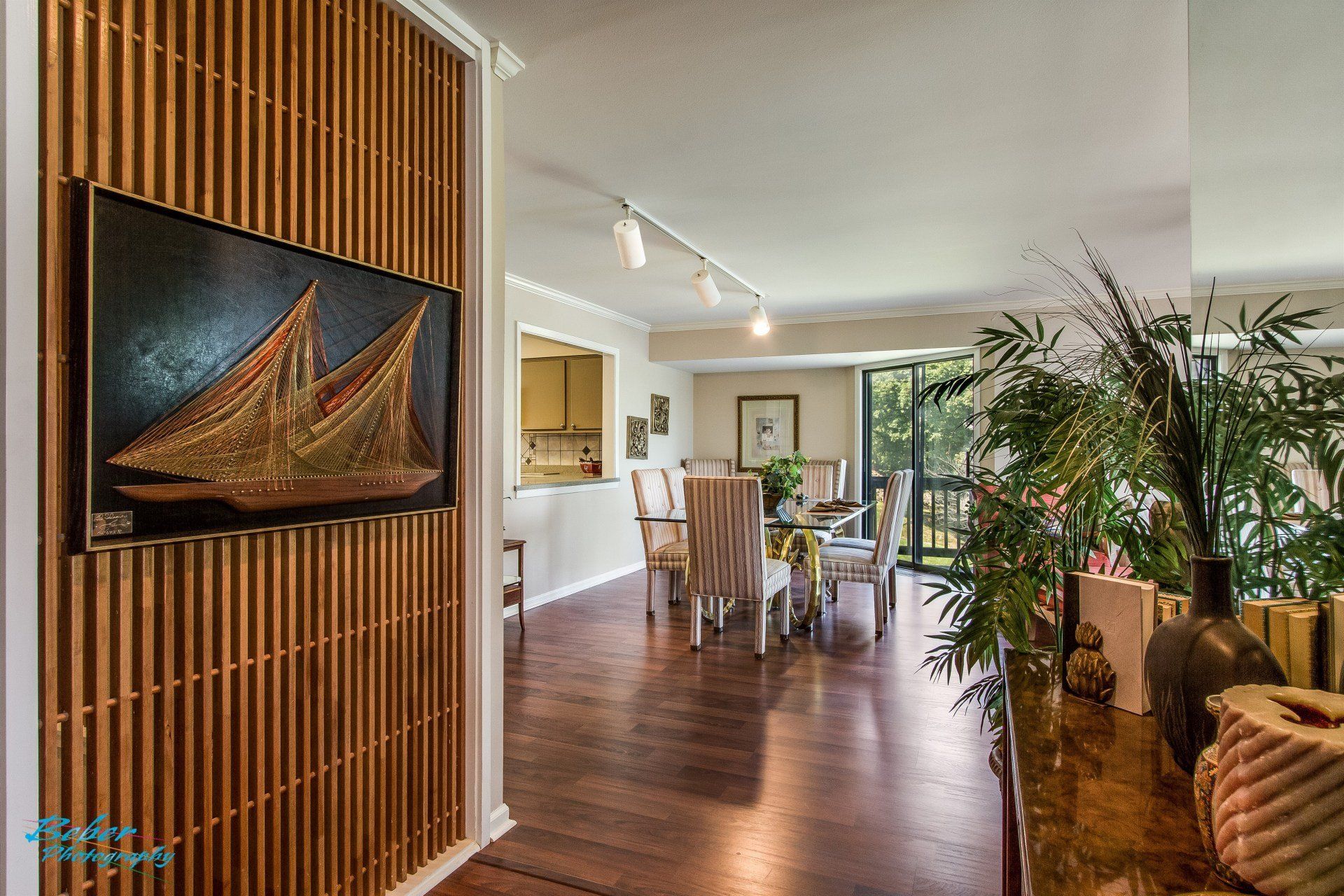 A living room with a wooden wall and a painting of a sailboat on the wall.