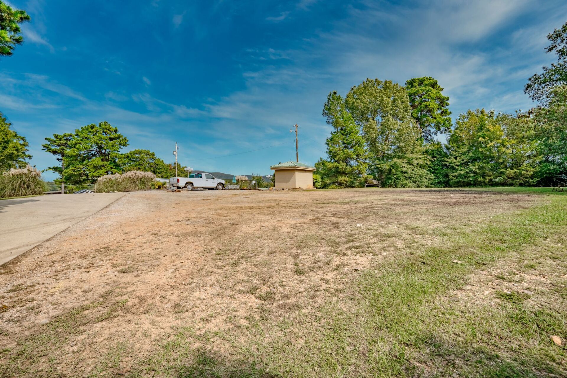 A white truck is parked in the middle of a grassy field.